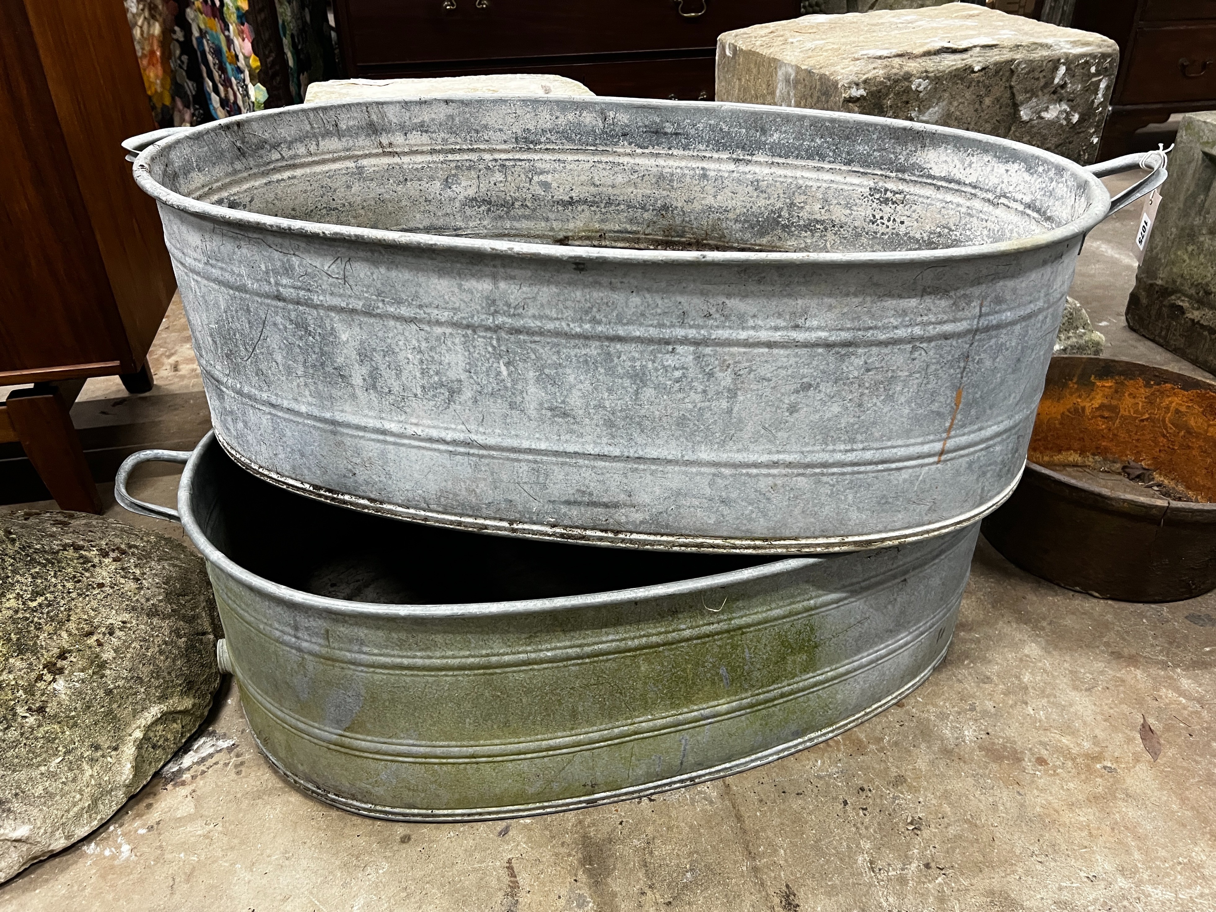 A pair of oval vintage galvanised zinc water troughs, length 104cm, depth 58cm, height 28cm together with a smaller circular cast iron planter